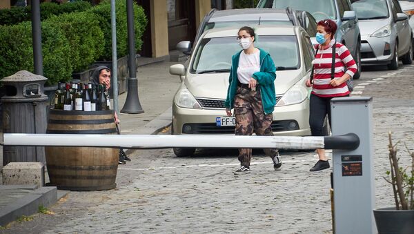 Женщины в масках идут по улице в центре грузинской столицы - Sputnik Грузия