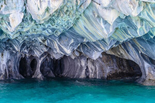 Одно из самых красивейших мест на нашей необъятной планете находится на границе Чили и Аргентины в Патагонских Андах. Мраморные пещеры - сказочное творение, которое создала сама природа, расположено в Южной Америке в одном из самых глубоких озер мира - Буэнос-Айресе - Sputnik Грузия