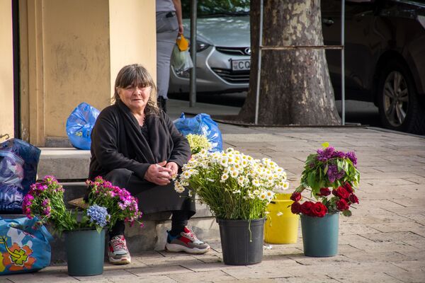 А этой женщине некогда думать - она уже пытается заработать деньги на жизнь продажей цветов, расположившись на привычном месте - Sputnik Грузия