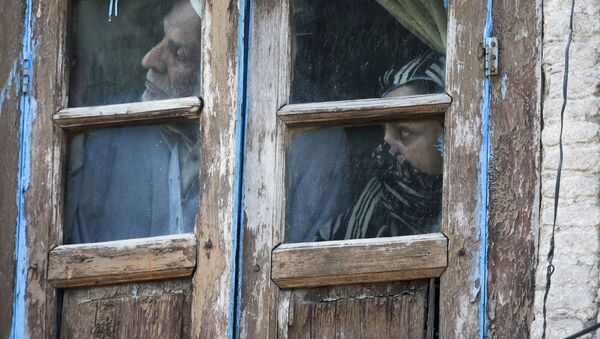 Люди смотрят из окна своего дома в Сринагаре, Индия - Sputnik Грузия