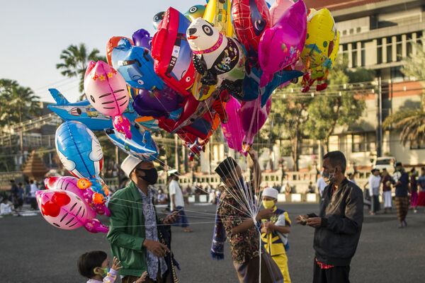 В большинстве государств, где отмечается Ураза-байрам, дни празднования являются выходными. На фото индонезийцы во время покупки шаров в честь празднования Ид-аль-Фитра в Сурабае - Sputnik Грузия