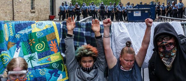 Протестующие с поднятыми руками в знак солидарности с убитым Джорджем Флойдом у полицейского участка в Миннеаполисе Протестующие с поднятыми руками в знак солидарности с убитым Джорджем Флойдом у полицейского участка в Миннеаполисе - Sputnik Грузия