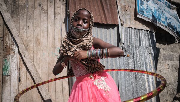 Девочка-сирота с новым обручем во время раздачи еды и игрушек детям-сиротам в 11-ти детских домах в связи с праздником Ураза-байрам в Кении - Sputnik Грузия