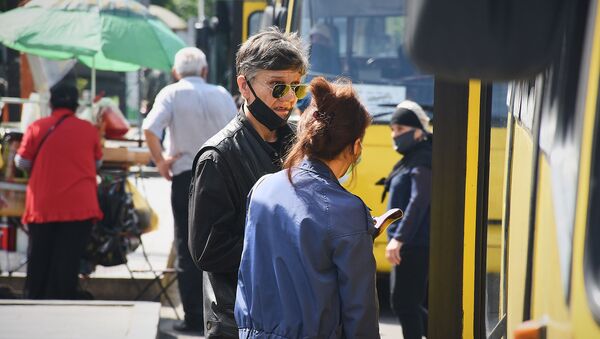 Городской транспорт. Пассажиры в масках на автобусной остановке - Sputnik Грузия