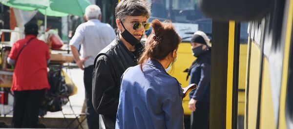 Городской транспорт. Пассажиры в масках на автобусной остановке - Sputnik Грузия