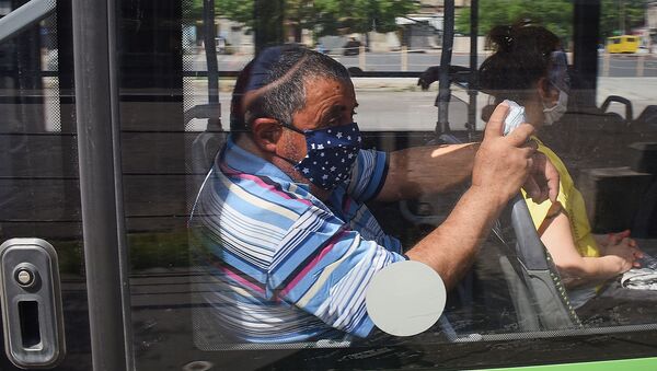 Городской транспорт. Пассажиры в масках едут в автобусе - Sputnik Грузия