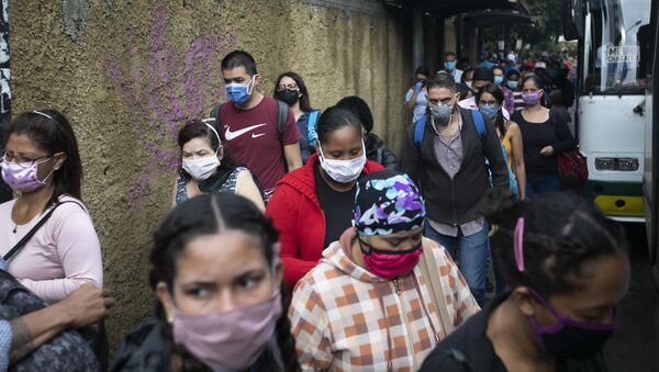 Пешеходы в масках идут по улице в Каракасе, Венесуэла. Пандемия коронавируса не отступает - Sputnik Грузия