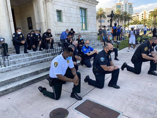 В нескольких городах США полицейские встали на одно колено перед участниками акций протеста, связанных с трагичной смертью Джорджа Флойда - Sputnik Грузия