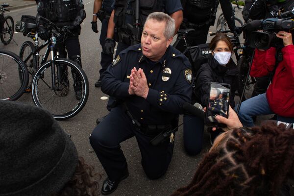 Начальник полиции Белвью, штат Вашингтон, Стив Милет становится на колени рядом с демонстрантами в знак протеста против смерти Джорджа Флойда - Sputnik Грузия