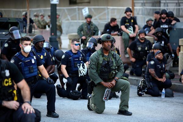 В одном из городов офицеры встали на колено, а протестующие стали выкрикивать имена погибших афроамериканцев. И они вместе, хором, начали их повторять - Sputnik Грузия