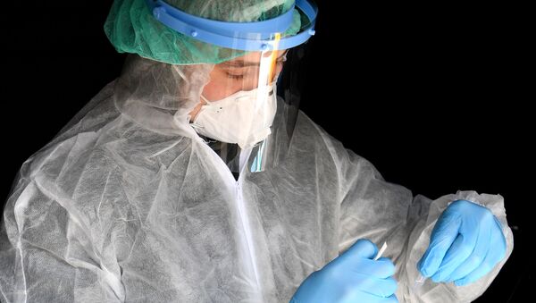 Сотрудник клиники проверяет биоматериал пациентов на наличие коронавируса - Sputnik Грузия