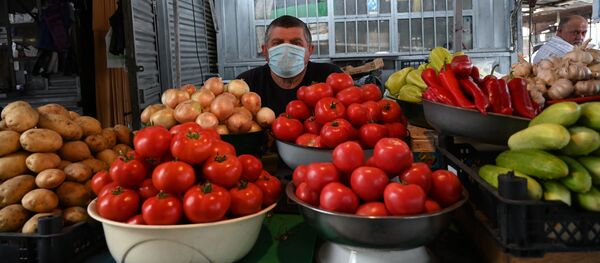 Торговцы и покупатели в медицинских масках на одном из продуктово-овощных рынков - Sputnik Грузия