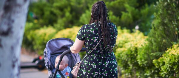 Женщина с интересной прической косичками идет с коляской по улице - Sputnik Грузия