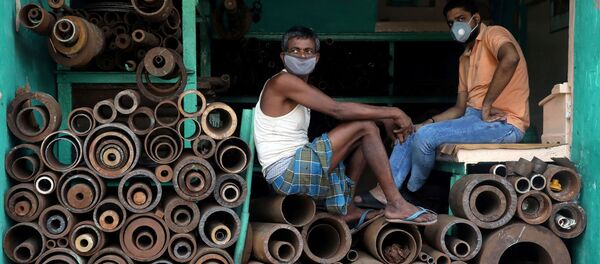 Рабочие в защитных масках в магазине, торгующем железными трубами на оптовом рынке в Калькутте, Индия - Sputnik Грузия