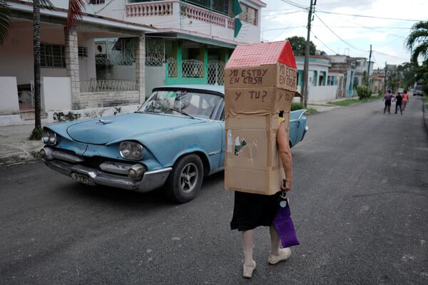 Женщина в картонной конструкции для защиты от коронавируса на улице в Гаване - Sputnik Грузия