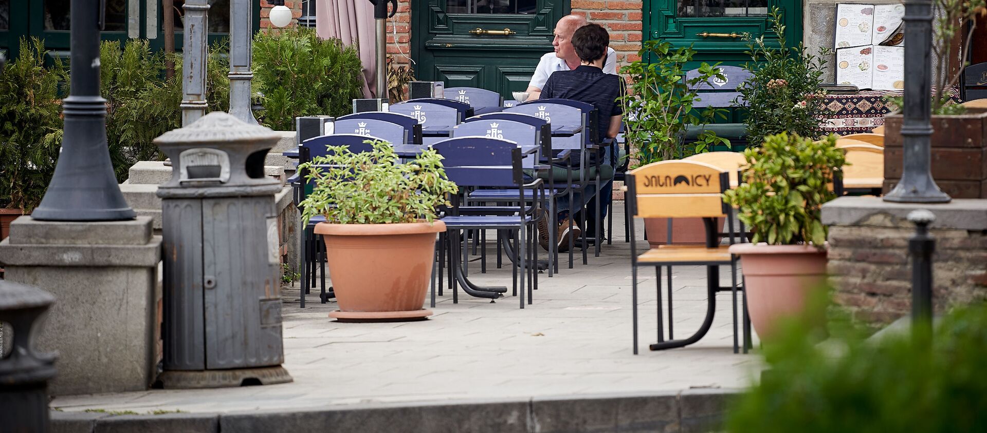 Пустующие столики в уличном кафе. Редкие посетители - Sputnik Грузия, 1920, 12.08.2021