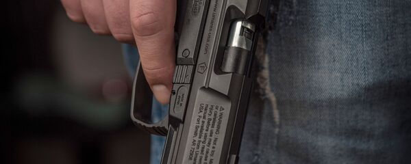 Человек держит в руке пистолет - Sputnik Грузия