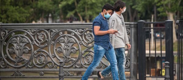 Молодые мужчины идут по центру города в защитных масках Молодые мужчины идут по центру города в защитных масках - Sputnik Грузия