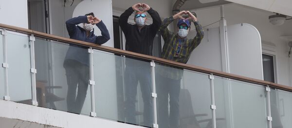 Жители Уругвая в масках показывают сердечки во время пандемии коронавируса - Sputnik Грузия