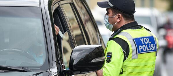 Полицейский в маске проверяет документы у водителя автомобиля в Баку - Sputnik Грузия