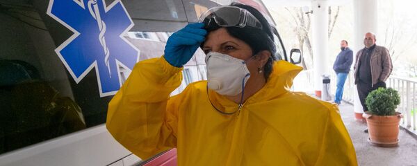 Медицинский работник перед зданием медицинского центра в Армении - Sputnik Грузия